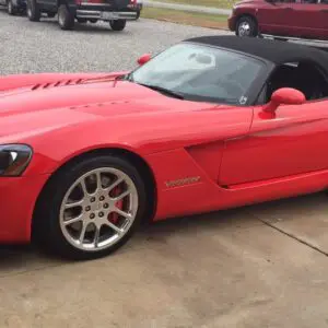 A red sports car parked in the driveway.