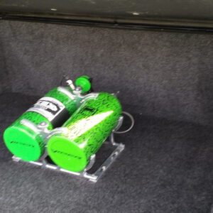 A green bottle and can sitting on the floor.