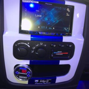 A car dashboard with a large screen and buttons.