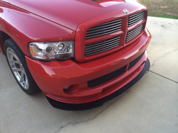 A red truck parked in the driveway of a house.