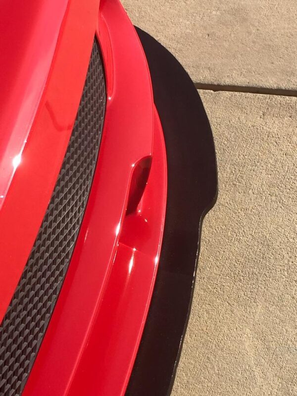 A close up of the side of a red car.