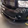 A black truck with its front end dented.