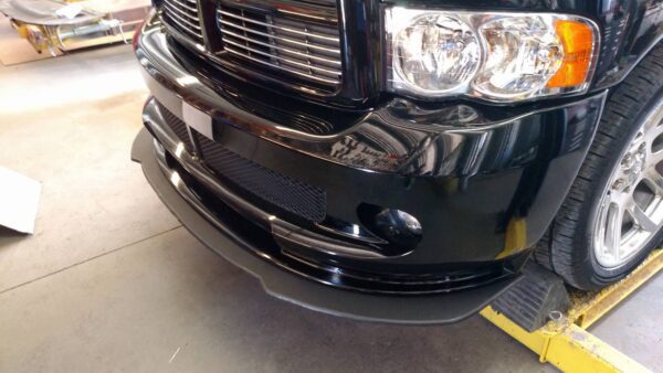 A black truck with its front end dented.