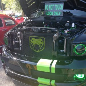 A black and green car with its hood open.