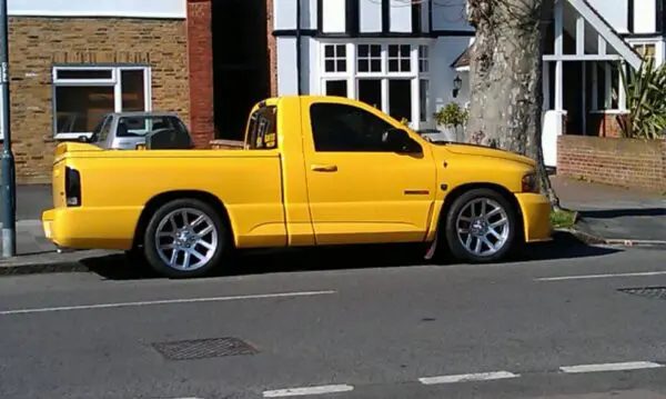 A yellow truck parked on the side of a street.