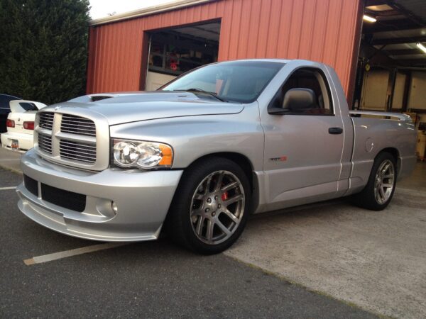 A silver truck parked in front of a building.