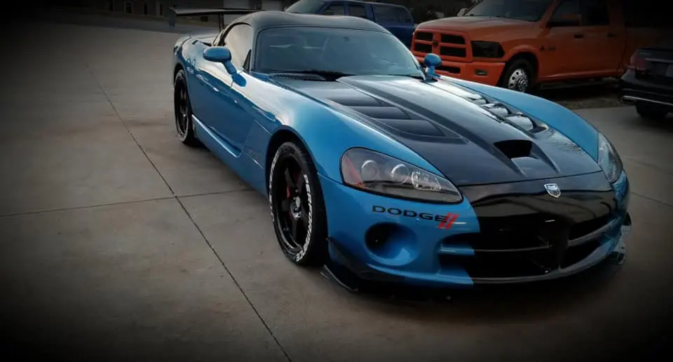 A blue dodge viper parked on the side of a road.