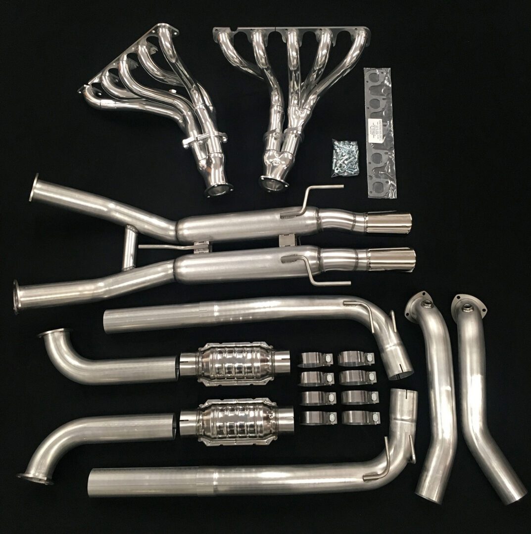 A set of exhaust pipes and headers are laid out on the table.