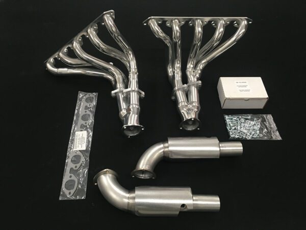 A set of exhaust pipes and headers are laid out on the table.