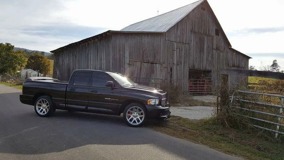A truck parked in front of a barn.