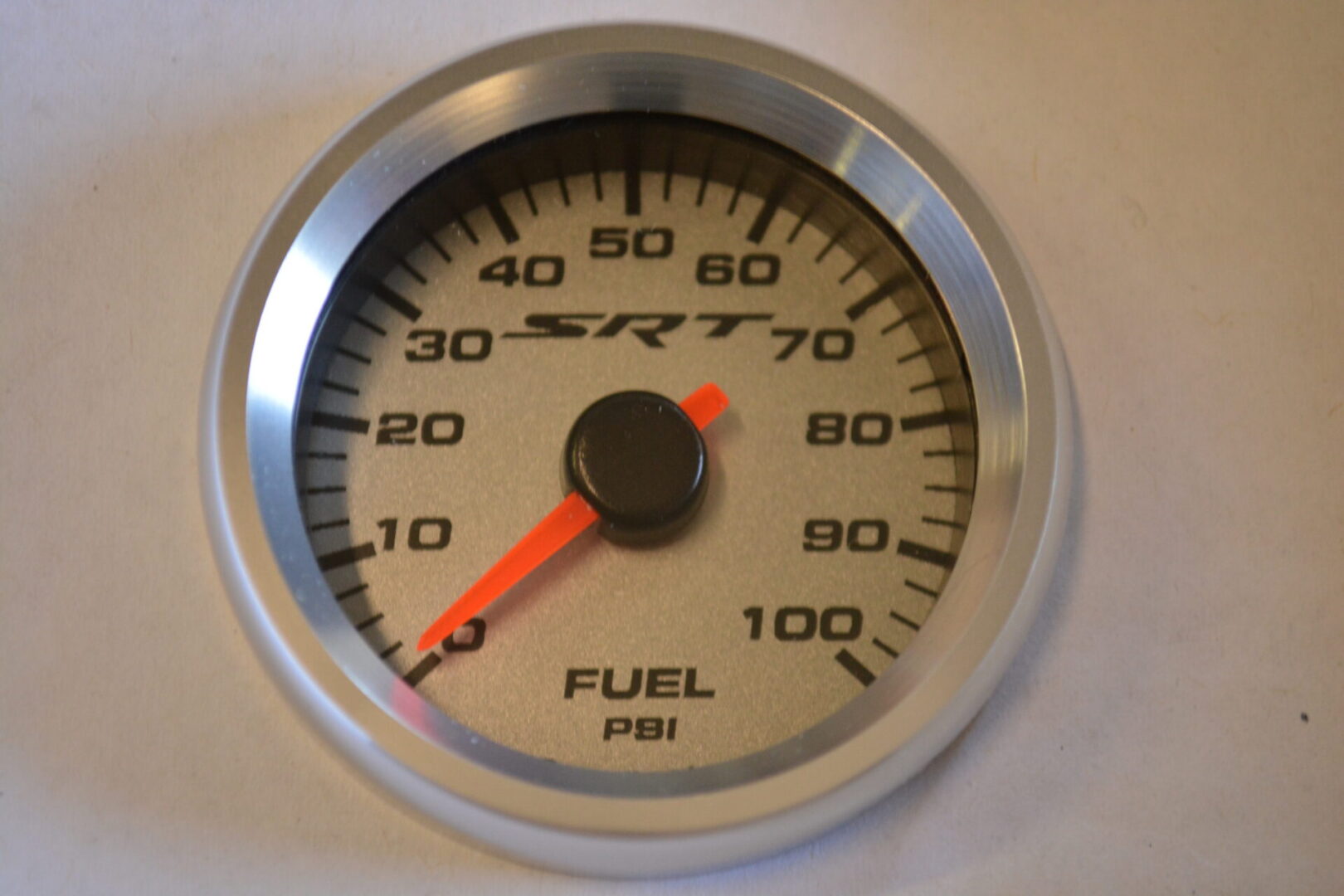 A fuel pressure gauge is shown with the needle pointing to 1 0 0 psi.