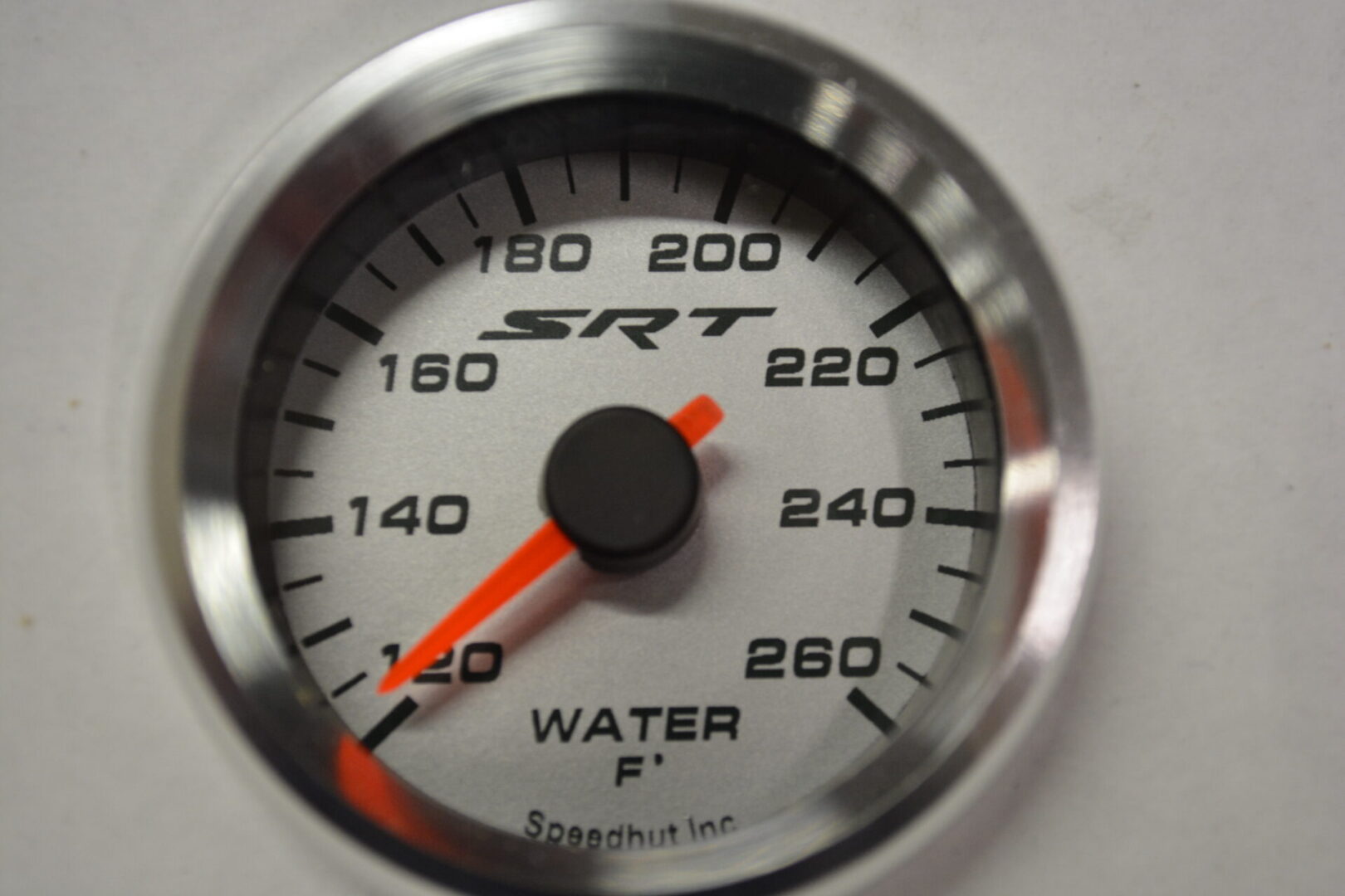 A white and silver gauge with the words " water f " on it.
