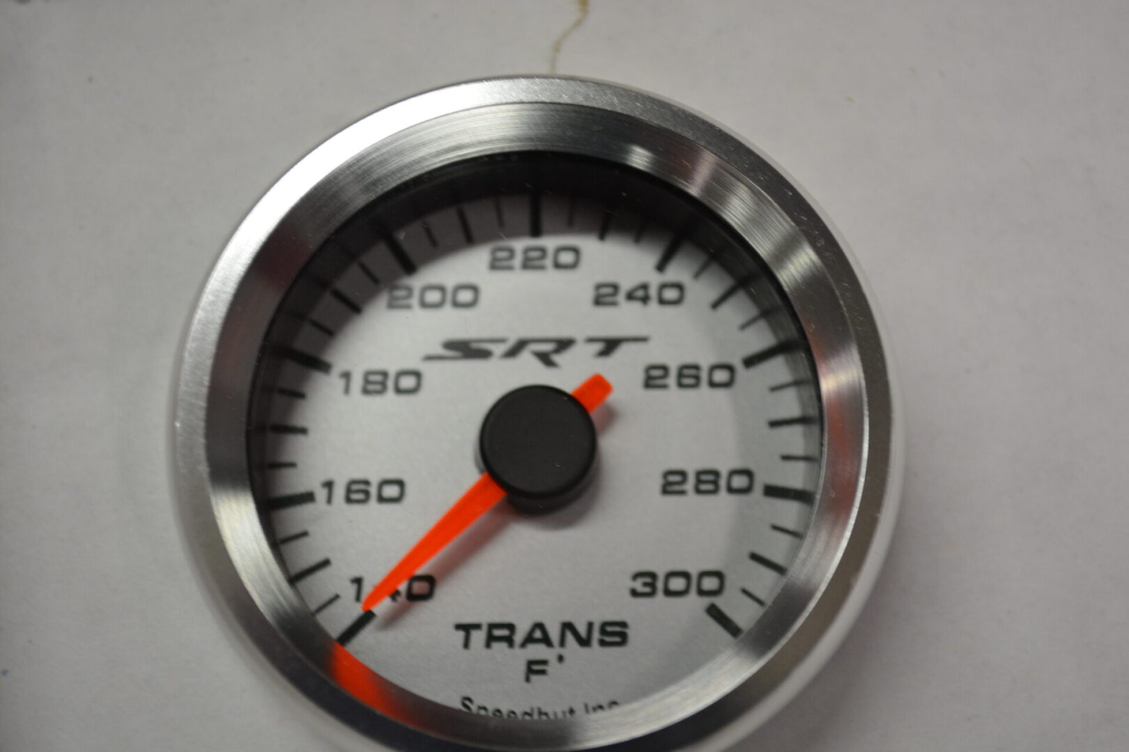 A white and silver gauge with red needle.