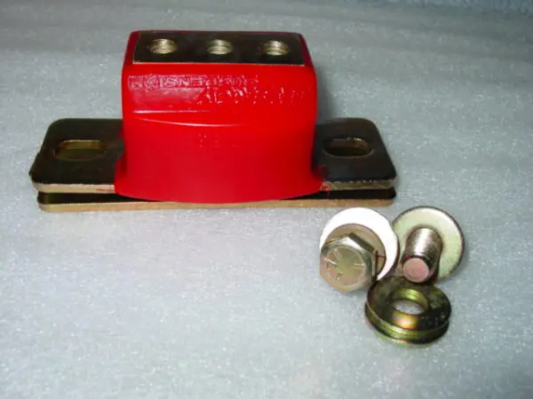 A red piece of metal sitting next to some other items.