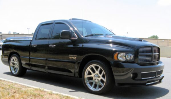 A black truck is parked on the side of the road.