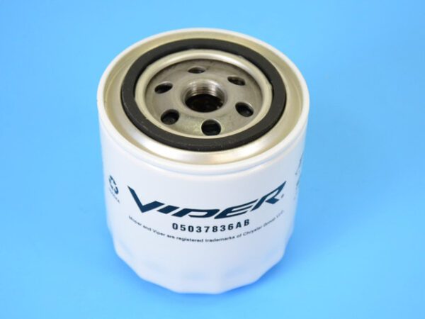 A white and black oil filter sitting on top of a blue table.
