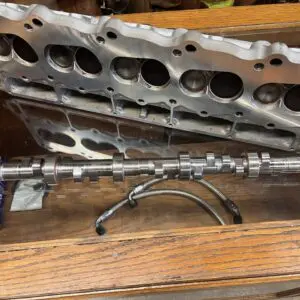 A metal cylinder head sitting on top of a wooden table.