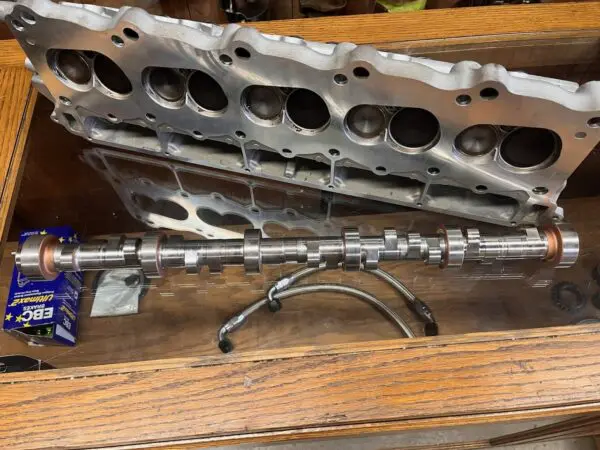 A metal cylinder head sitting on top of a wooden table.