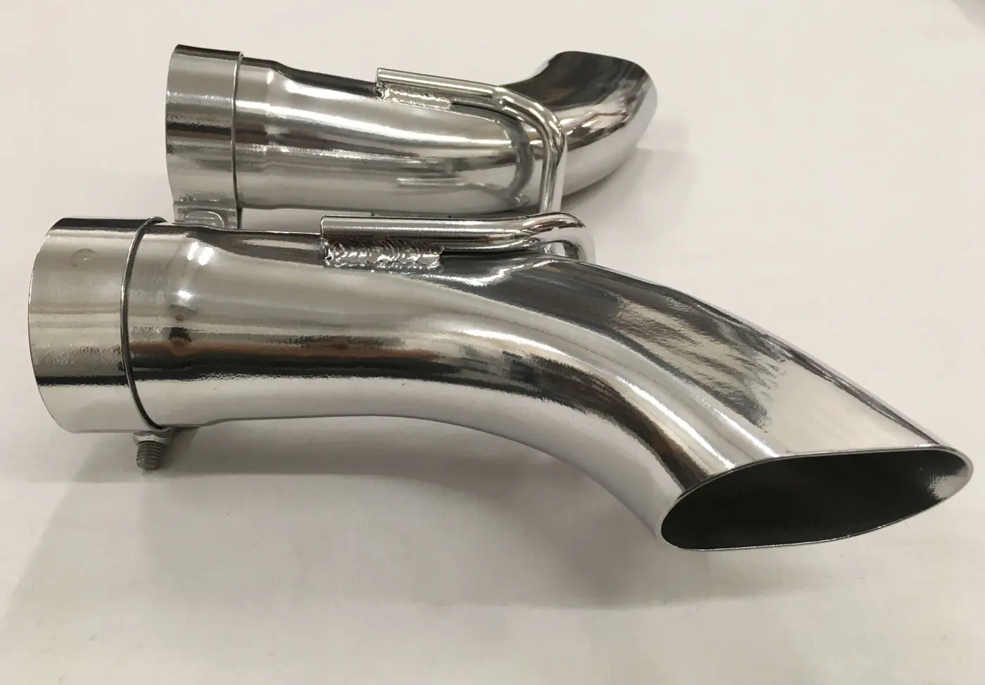 A chrome exhaust pipe sitting on top of a white table.
