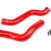 A pair of red hoses are laying on the ground.