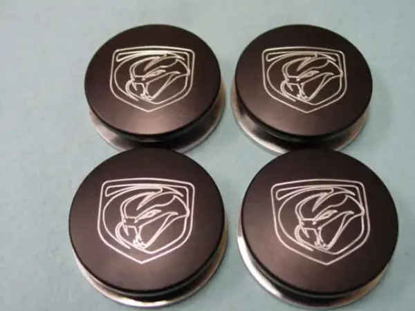 A set of four black and silver logo buttons.