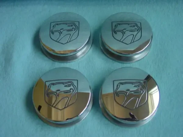 A set of four chrome rims with the logo for dodge.