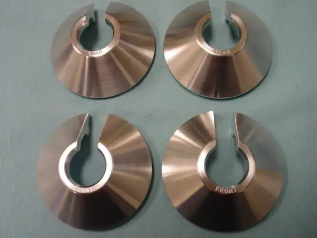 A set of four copper discs with one hole in the middle.