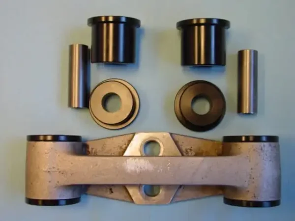 A pair of metal arms and two large black bushings.