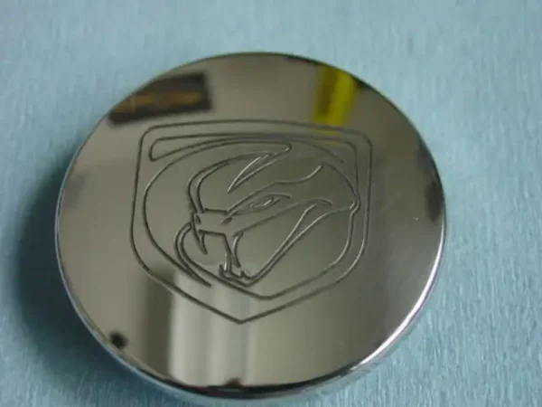 A close up of the logo on a chrome disc.