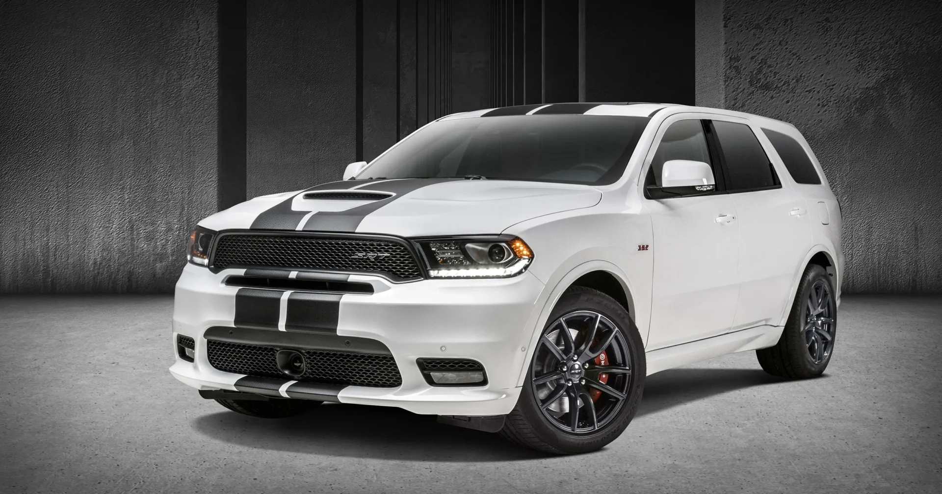A white dodge durango parked in front of a building.